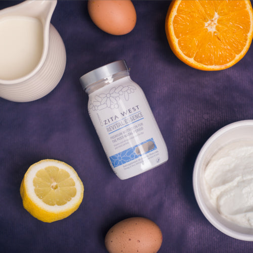 Zita West Revital Essence supplement bottle surrounded by eggs, citrus fruit and yoghurt