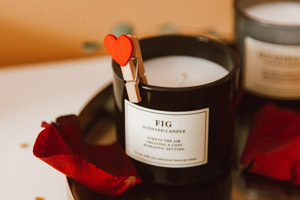 Black fig-scented candle decorated with a heart clothespin and rose petals