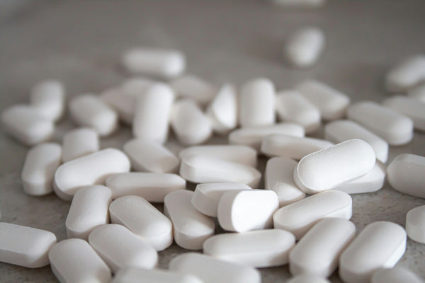 Close-up of scattered white tablets on a grey surface