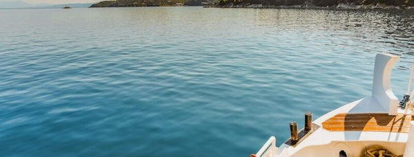 View of a calm blue bay from the bow of a small boat