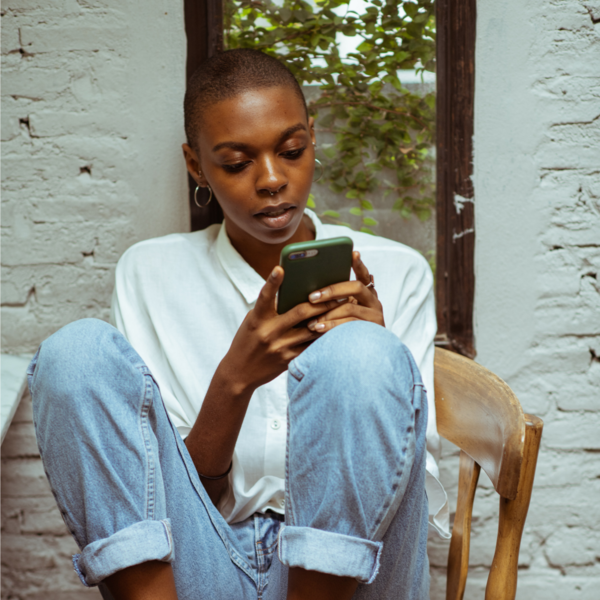 Woman sitting by a window looking at her phone