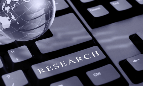 Glass globe resting on a keyboard key labeled RESEARCH
