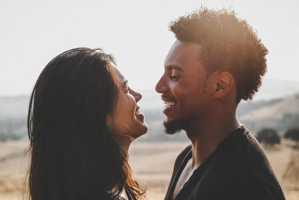 Couple smiling face to face outdoors at sunset