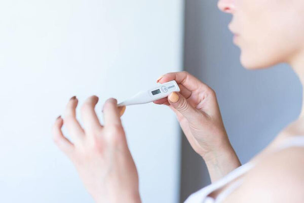 Woman checking a digital basal body thermometer