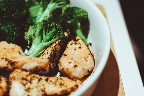 Bowl of seasoned grilled chicken pieces with broccoli