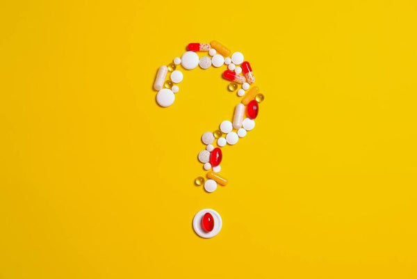 Vitamin pills and capsules arranged in the shape of a question mark