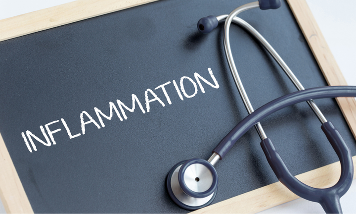 Chalkboard with 'Inflammation' written in white chalk, resting beside a stethoscope