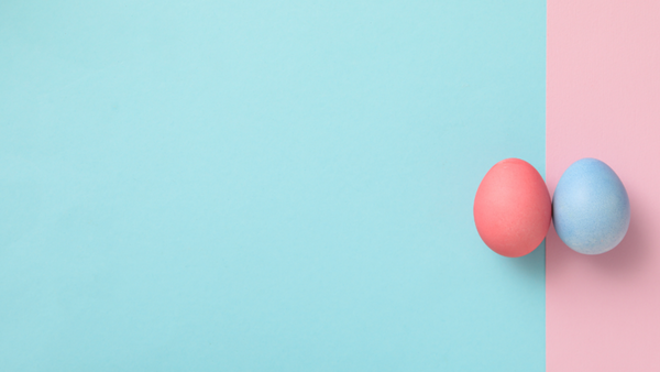 Two pastel-coloured Easter eggs, one pink and one blue, against a split pink and mint green background