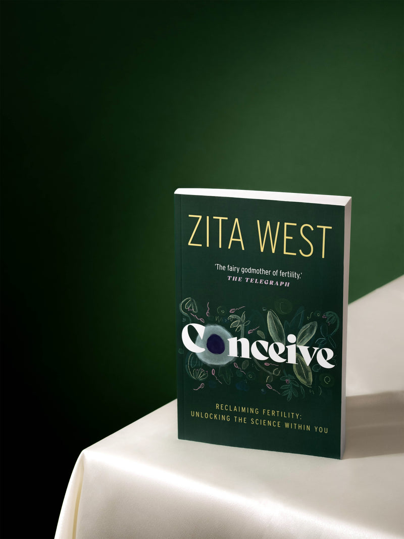 Book titled 'Conceive' by Zita West on a white surface with a green background