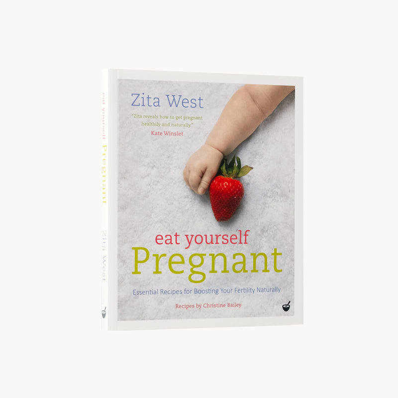Book cover of 'Eat Yourself Pregnant' by Zita West with a hand holding a strawberry.