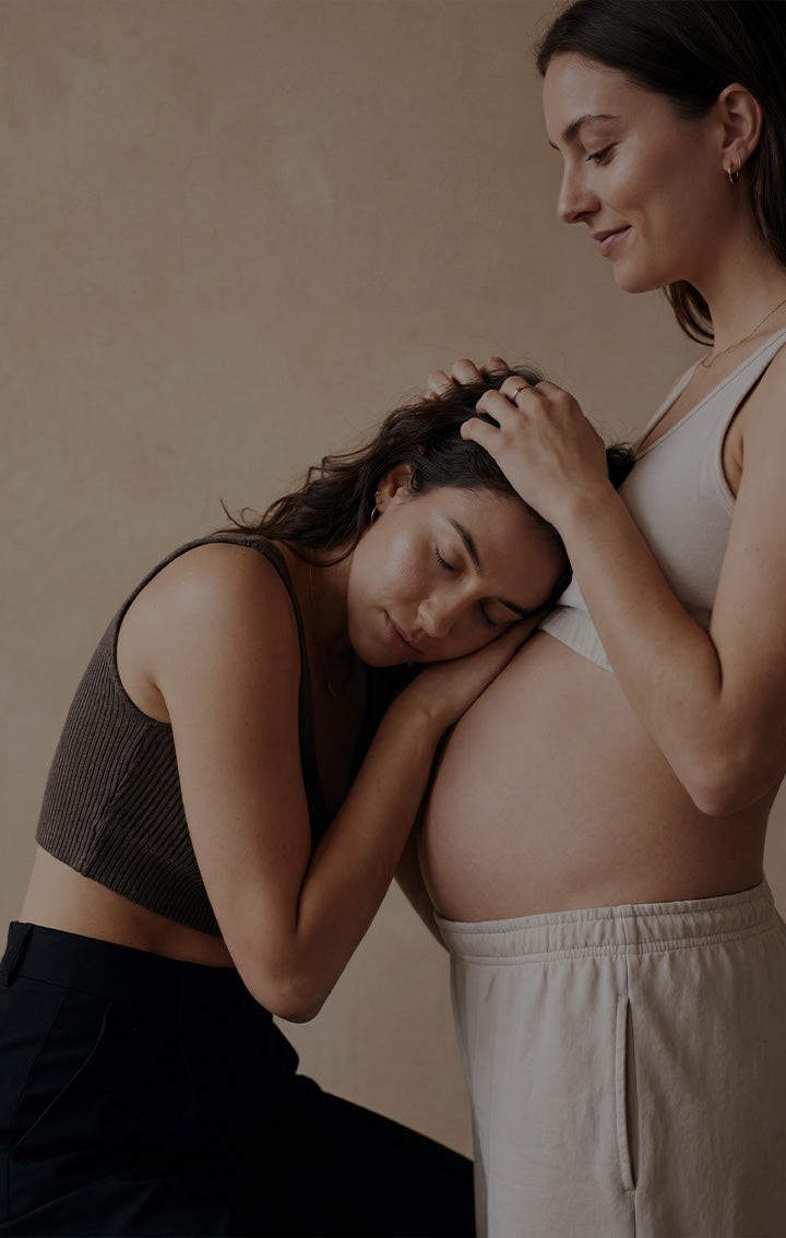 A couple cradling a baby bump