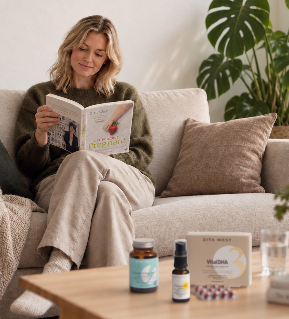 A woman reading Zita West's Eat Yourself Pregnant. In the foreground are Zita West supplements